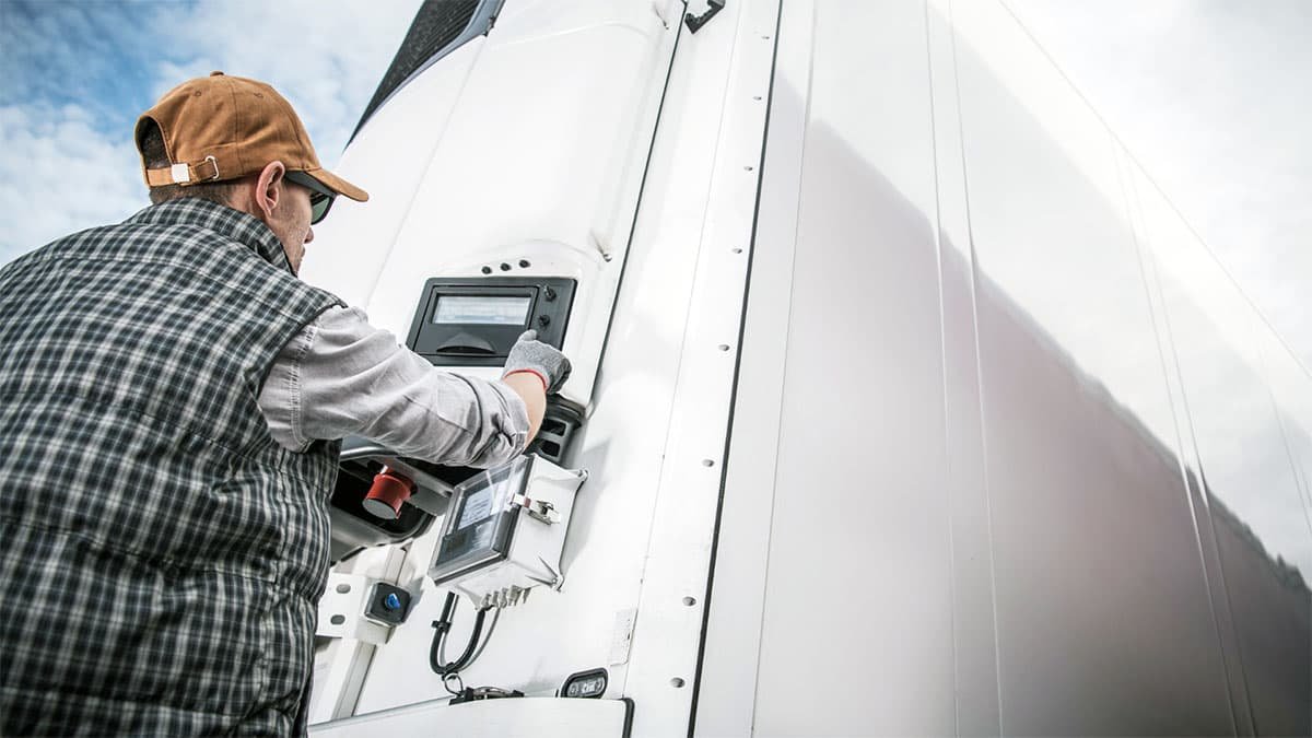 Technician working on the control panel of a white container